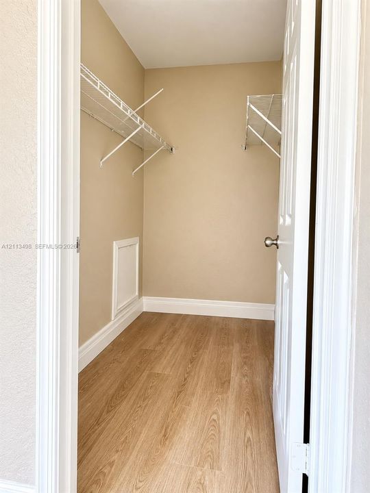 Storage space featuring wood-finish flooring and dual-level wire shelving