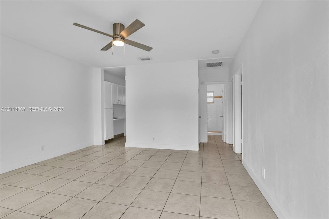 Neutral interior featuring tile flooring, smooth wall finishes, and a ceiling-mounted light fixture with a fan