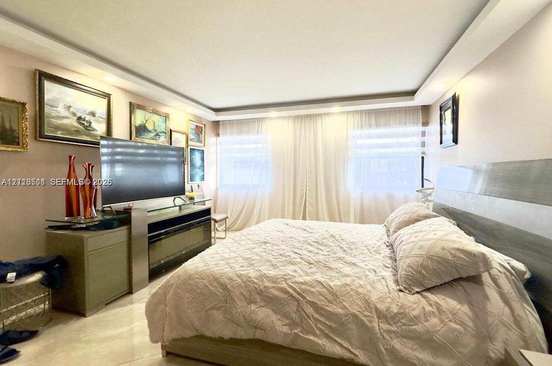 Tray ceiling with recessed lighting and large-format tile flooring