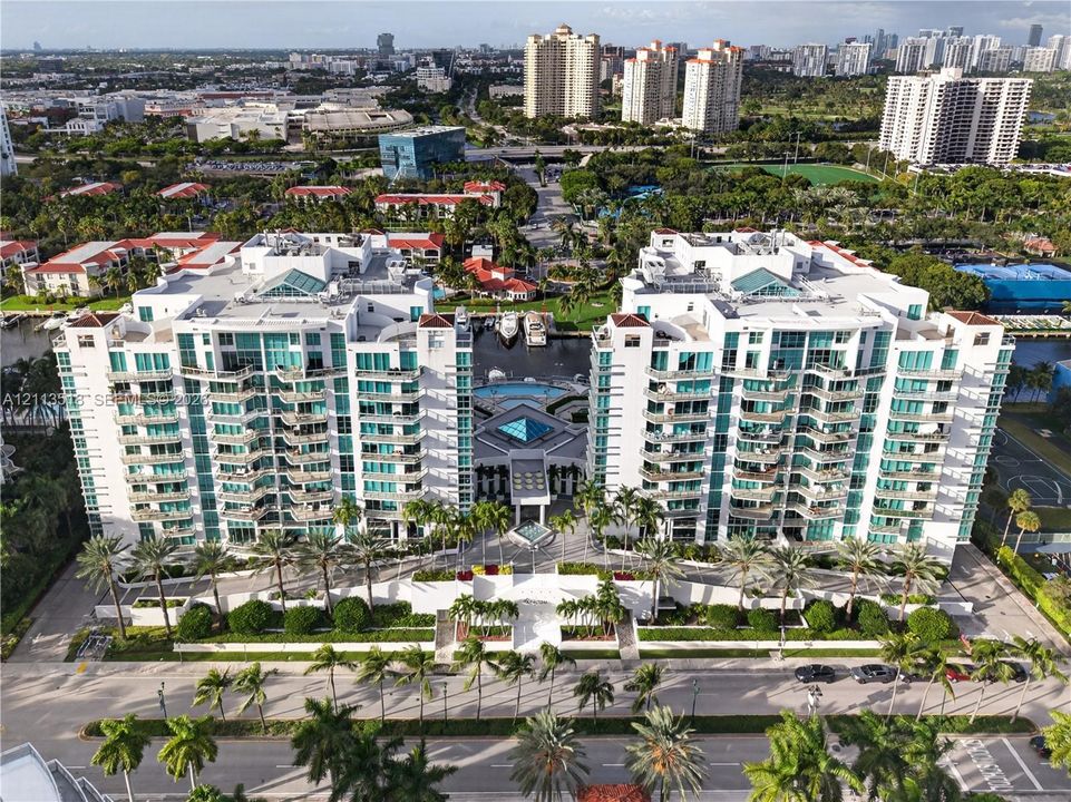 High-rise waterfront residential complex featuring private balconies, an on-site swimming pool, deep-water boat slips, and extensive perimeter landscaping