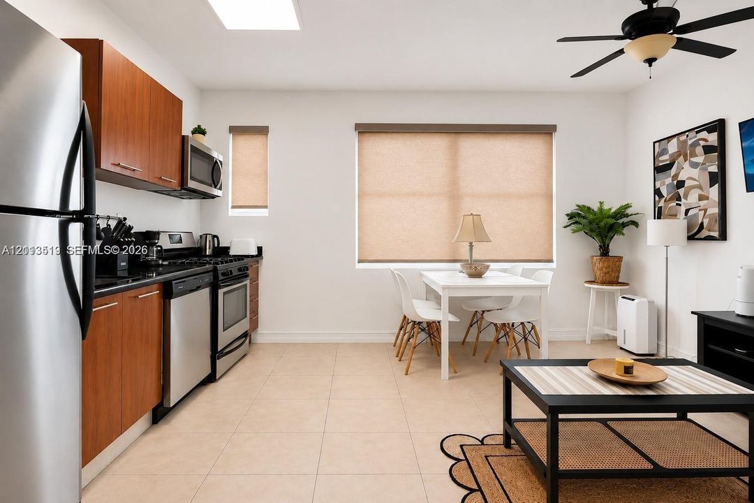 Kitchen featuring wood-finish cabinetry, stainless steel appliances, tile flooring, built-in microwave, and a ceiling fan