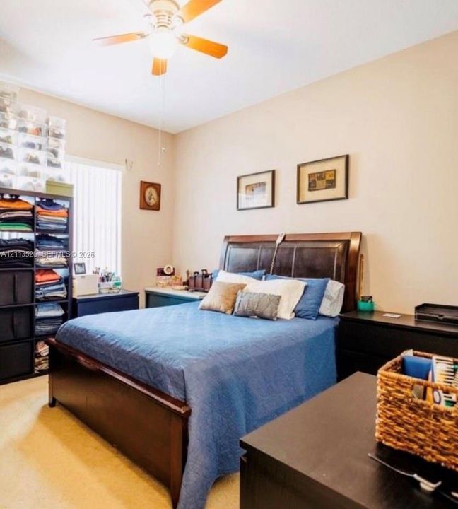 Neutral wall tones, carpeted flooring, and a ceiling fan with integrated lighting