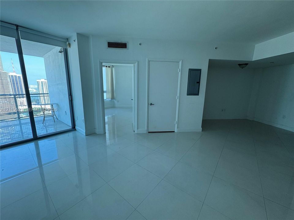 Large-format tile flooring, floor-to-ceiling glass sliding doors, and a private balcony