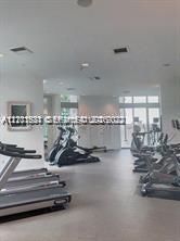Expansive fitness center featuring recessed lighting, smooth ceiling finish, and large-format flooring