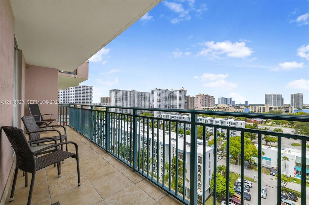 Covered balcony featuring tile flooring and a metal railing