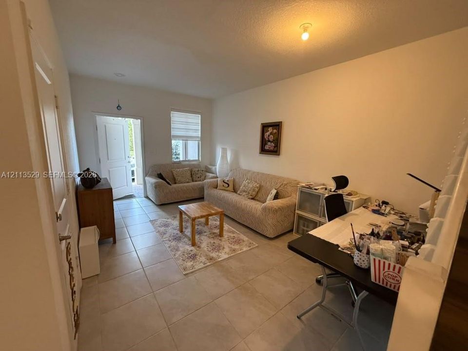 Neutral-toned tile flooring, recessed ceiling lighting, and a window with horizontal shade blinds