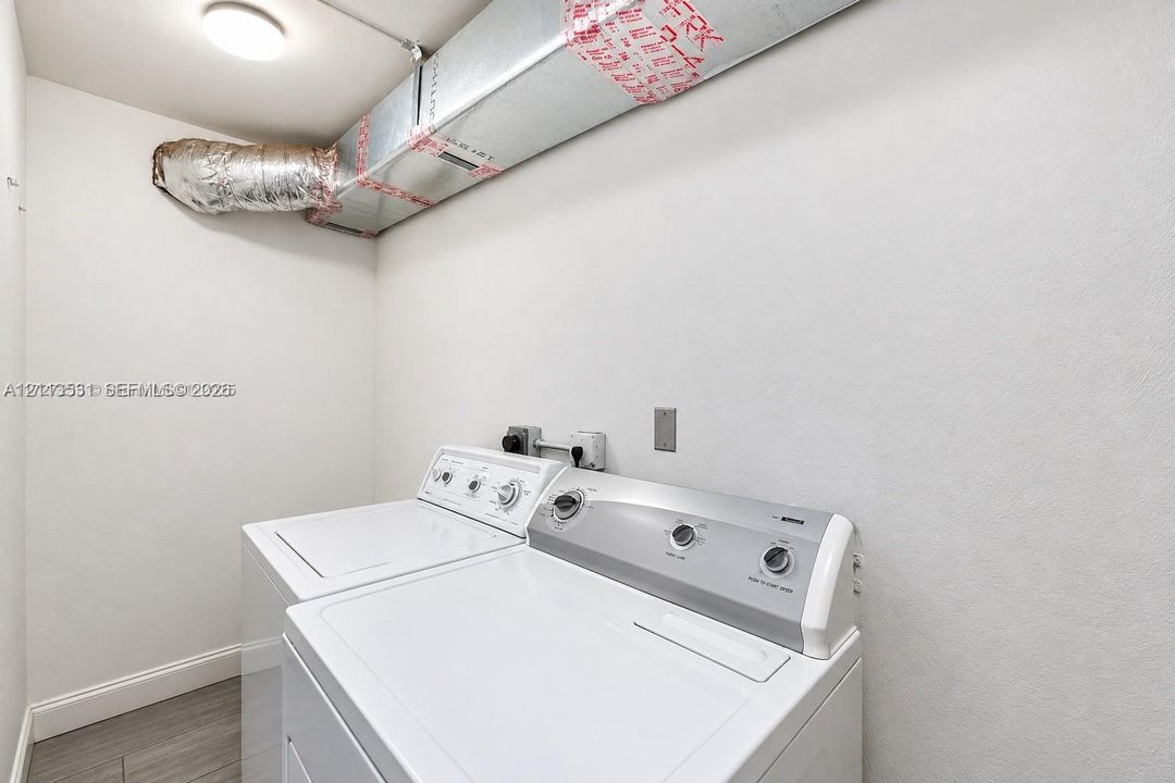 Utility area featuring wood-finish flooring and white walls