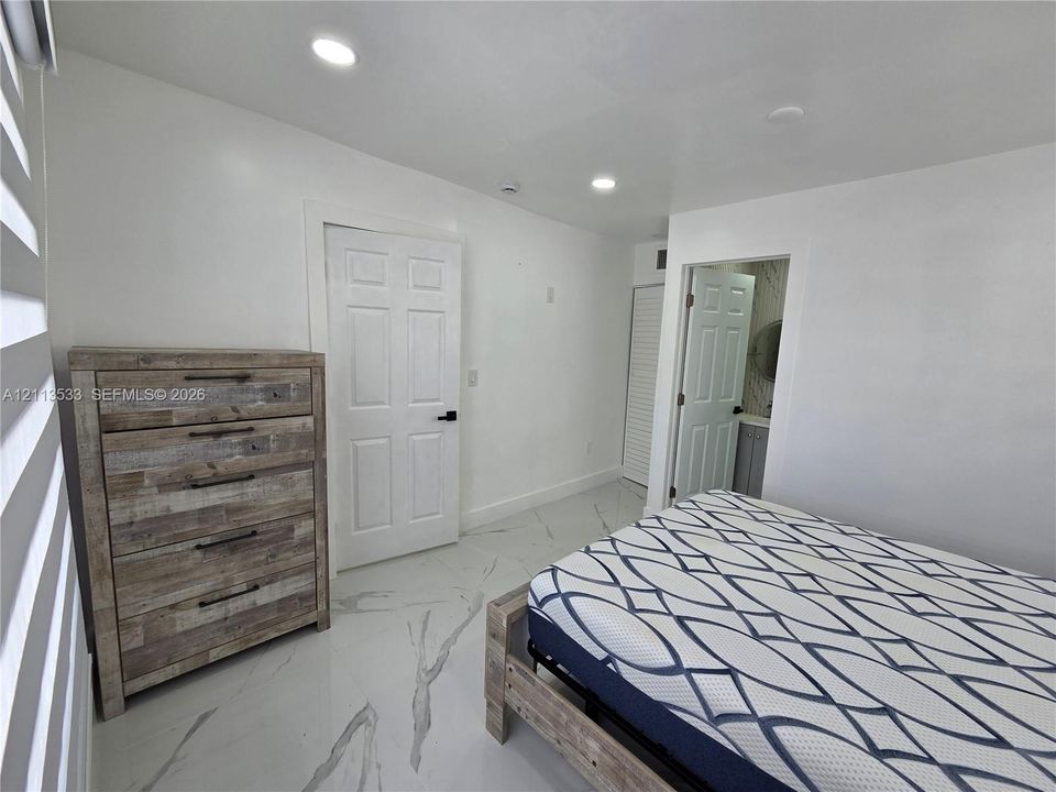 Large-format tile flooring with veined detailing, recessed ceiling lighting, and crisp white interior paint