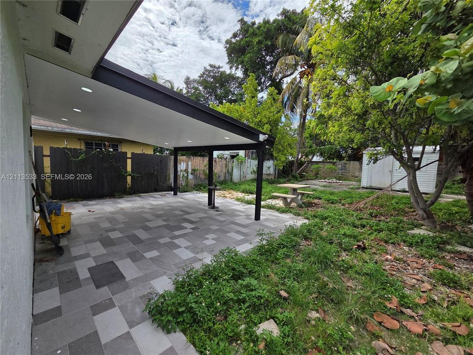 Covered patio featuring recessed lighting, a multi-tone tile floor, and a dark-finished structural support frame