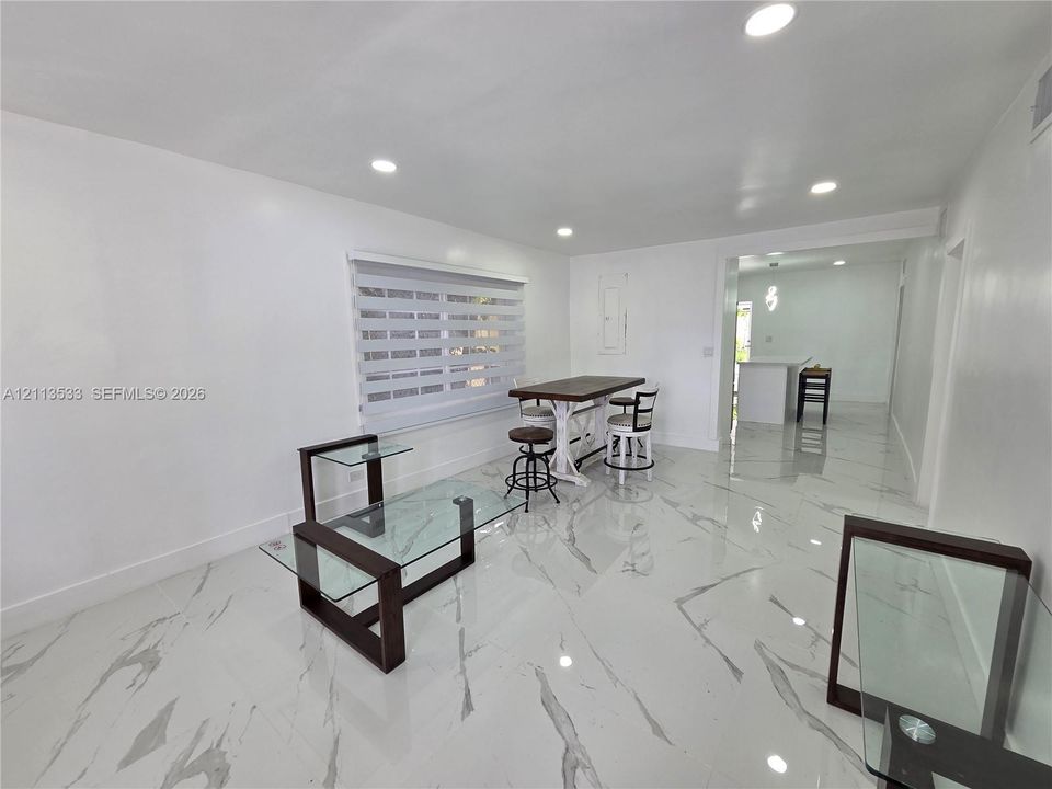 Polished large-format tile flooring with marble-pattern veining, recessed lighting, and dual-layered window shades