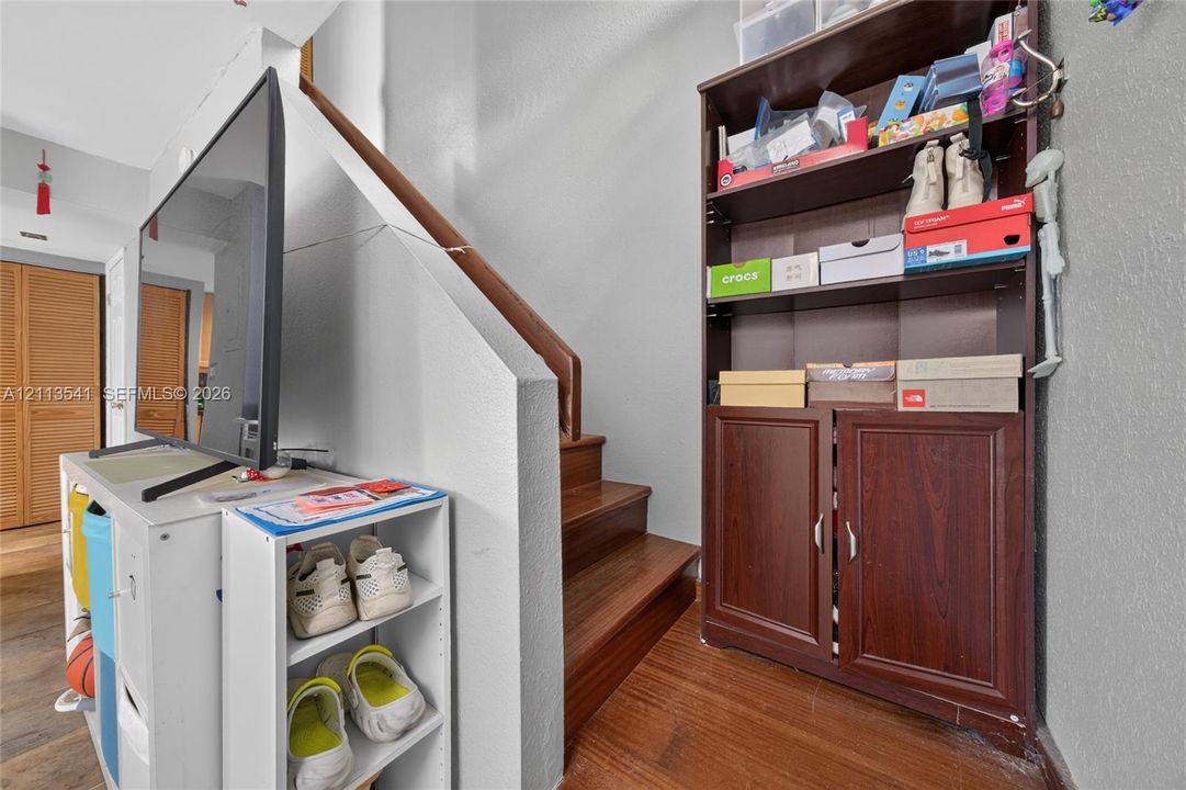 Staircase featuring wood-finish treads and a matching wooden handrail