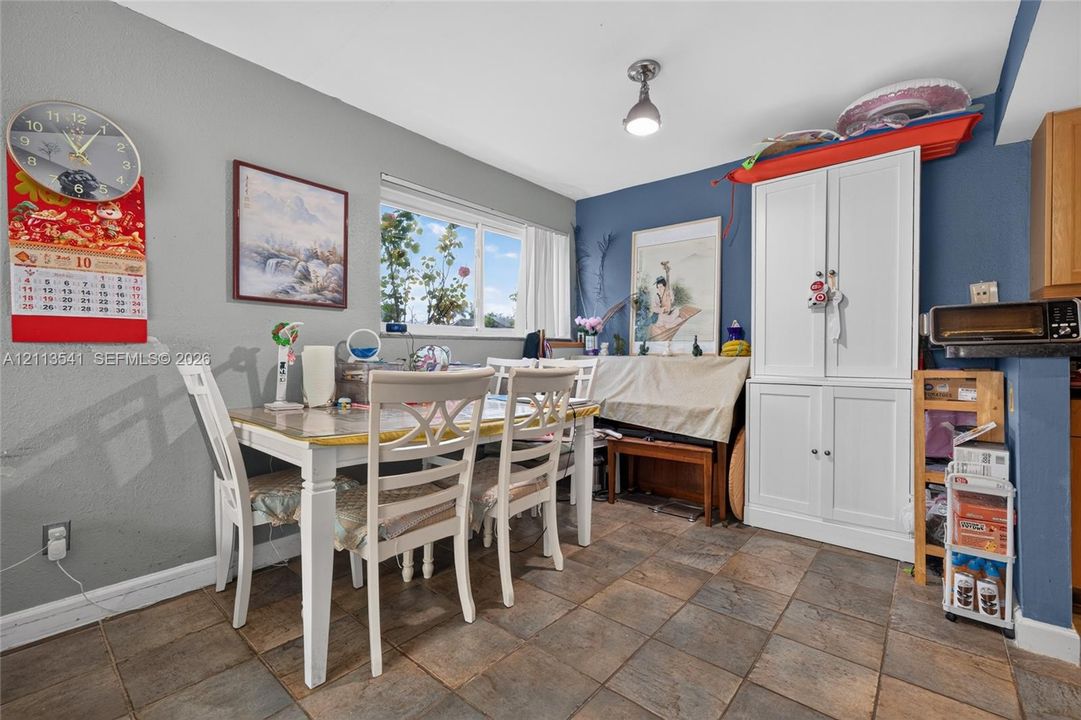 Built-in white storage cabinetry, stone-finish tile flooring, and a single-light fixture