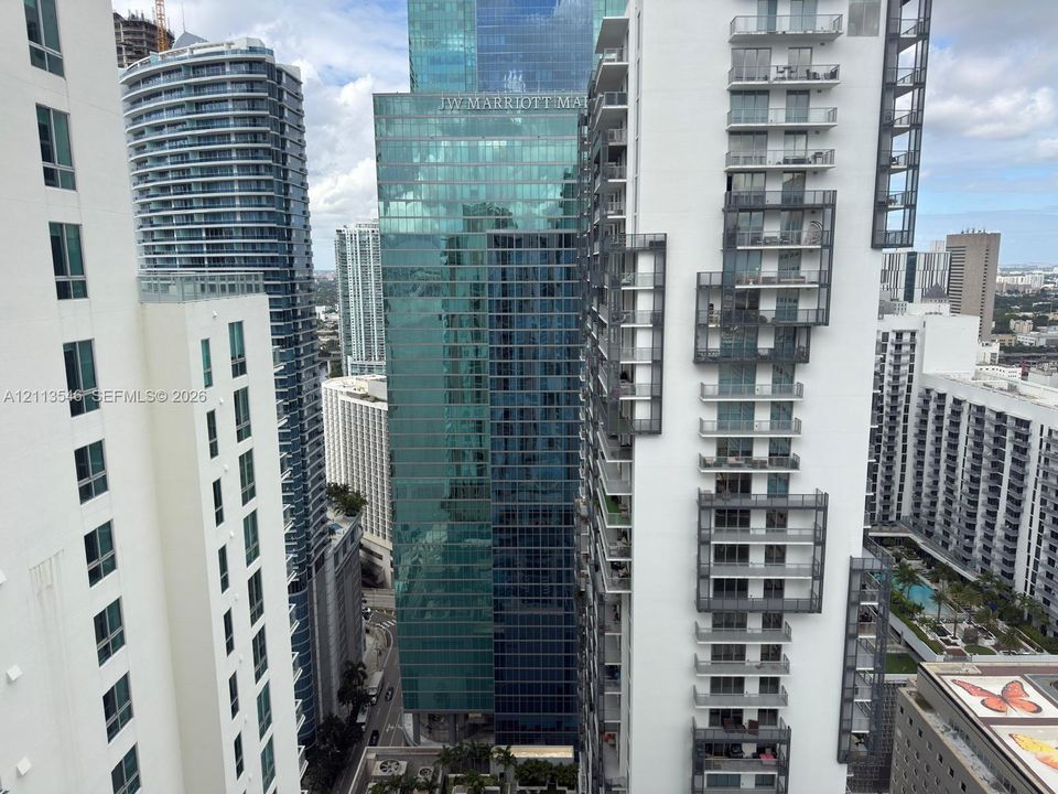 High-rise urban landscape featuring multiple glass-facade skyscrapers, architectural metal balconies, and dense metropolitan density