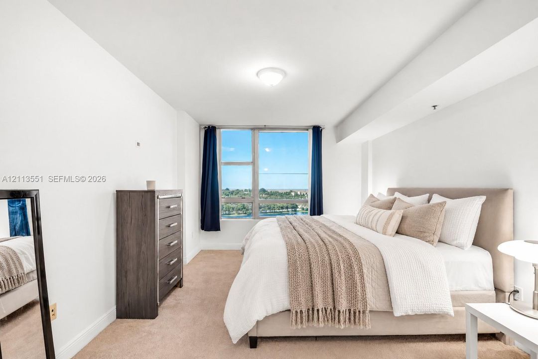 Neutral-toned carpeted flooring, expansive window, and ceiling-mounted light fixture