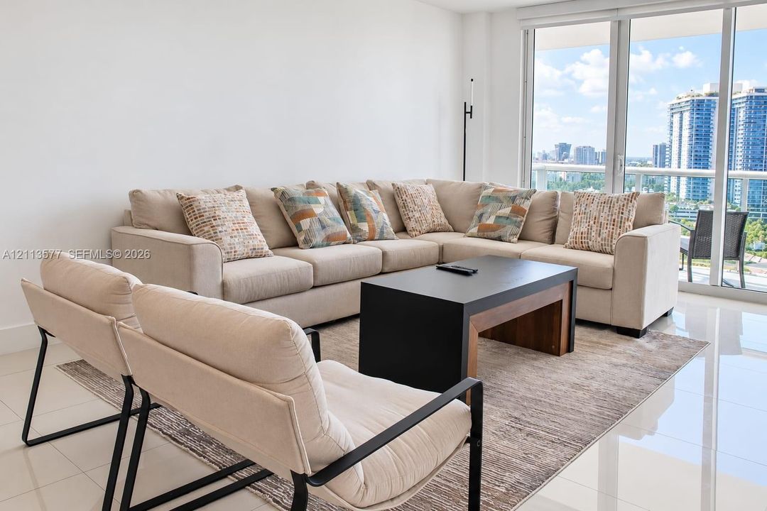 Floor-to-ceiling glass panel windows, polished tile flooring, and a glass-railed balcony