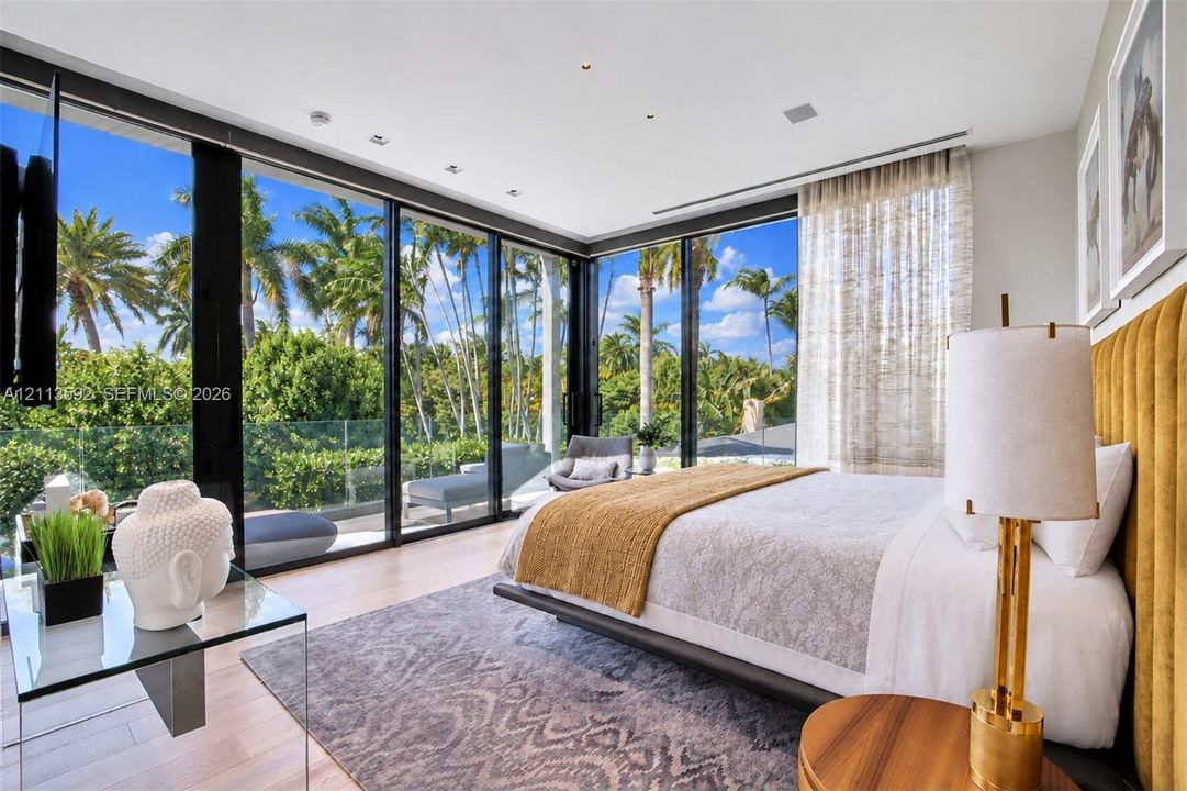 Floor-to-ceiling glass walls, recessed ceiling lighting, wood-finish flooring, and a glass-paneled exterior railing