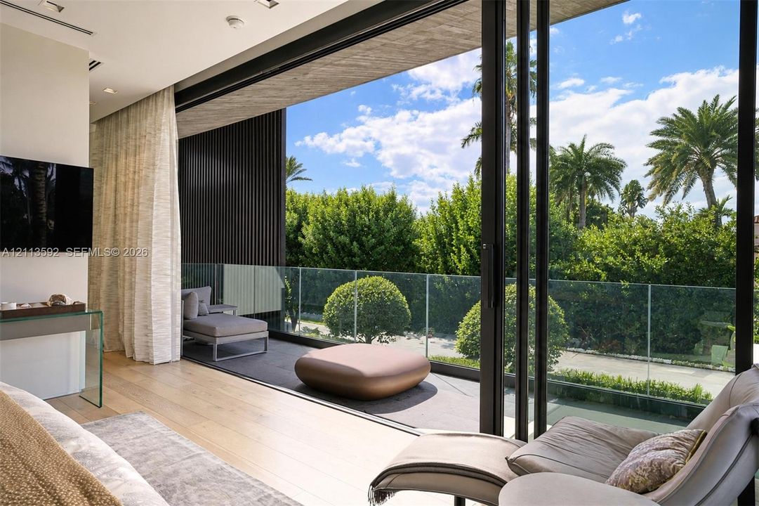 Floor-to-ceiling retractable glass walls, wood-finish flooring, recessed lighting, and a glass-paneled terrace