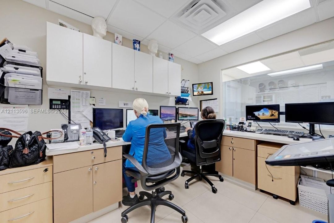 Office space featuring light-finish cabinetry, extensive built-in desk surface area, white upper storage cabinetry, recessed lighting, and tile flooring