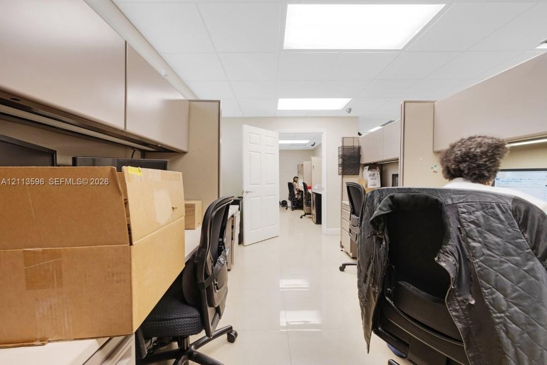 Work space featuring drop ceiling with recessed lighting, tile flooring, and integrated built-in cabinetry