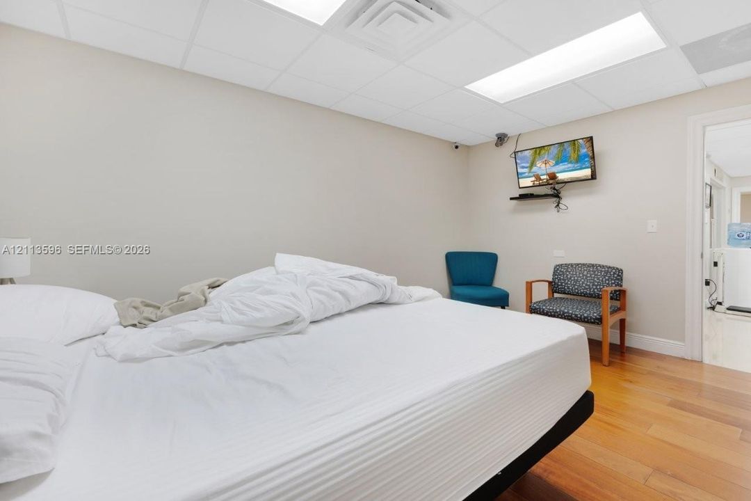 Room featuring wood-finish flooring, recessed lighting, and a drop ceiling