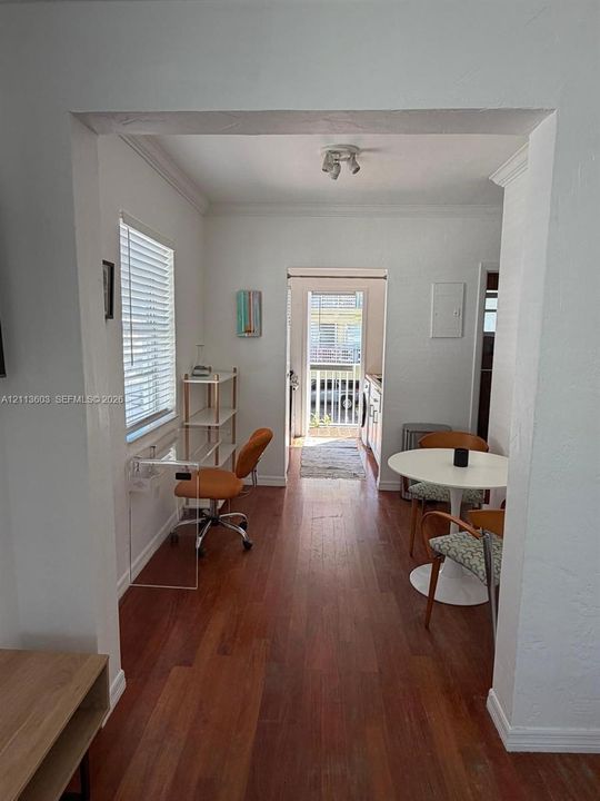 Wood-finish flooring, white walls, and horizontal slat window blinds