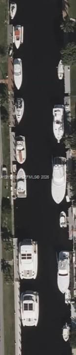 Aerial perspective of a deep-water canal featuring concrete bulkheads and multiple private dock structures