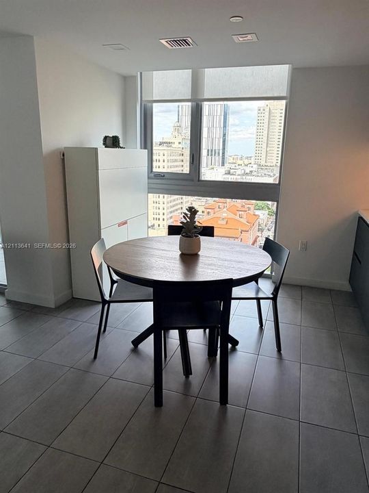 Large-format tile flooring, floor-to-ceiling windows with roller shades, and integrated cabinetry