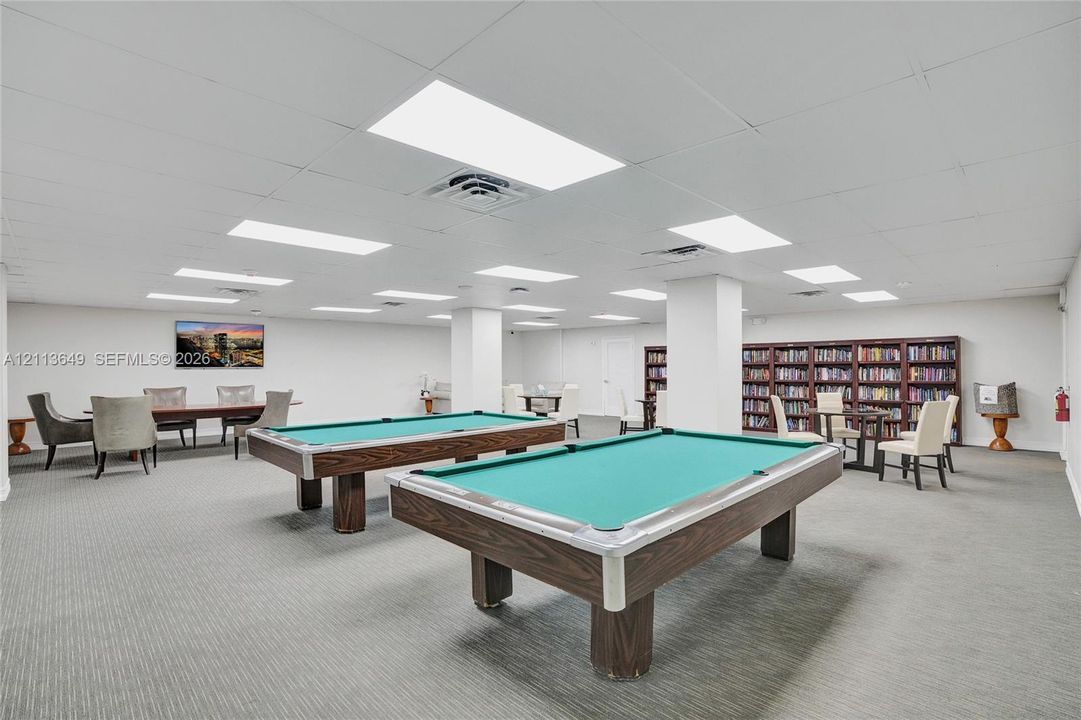 Expansive interior space featuring recessed ceiling lighting, wall-to-wall carpeting, and floor-to-ceiling built-in shelving units