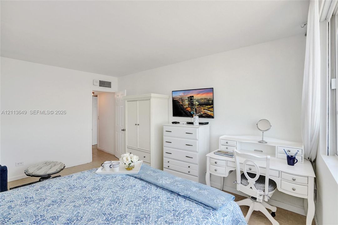 Neutral interior space featuring high ceilings, wall-to-wall carpeting, and floor-to-ceiling windows with drapery