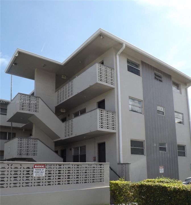 Multi-story exterior featuring decorative concrete block screen walls, vertical siding accents, and exterior staircases