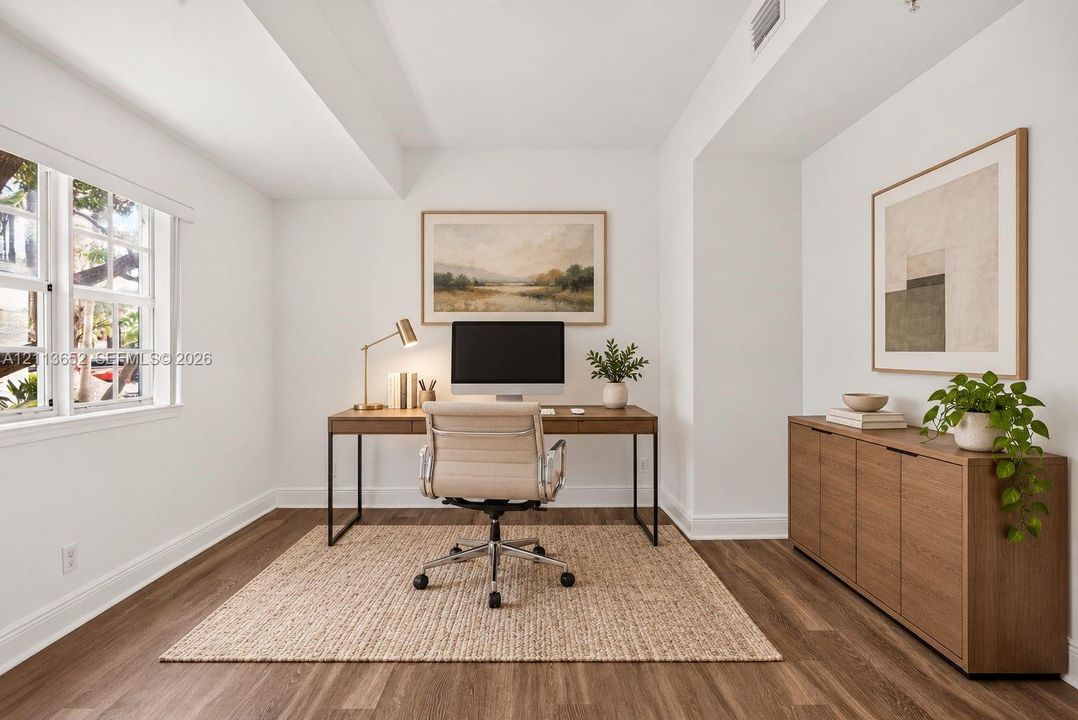 Room featuring wood-finish flooring, multi-pane window, and neutral walls