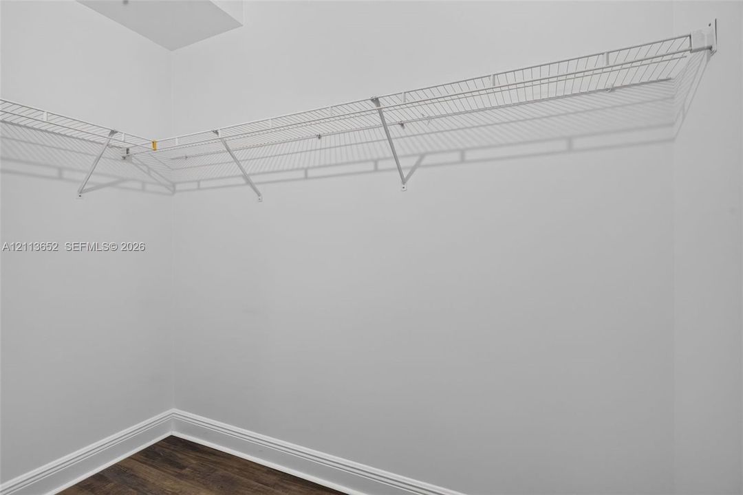 L-shaped white wire shelving and wood-finish flooring