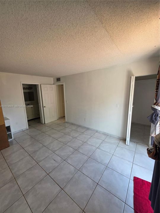 Neutral-toned tile flooring, solid-core interior doors, and white-painted walls