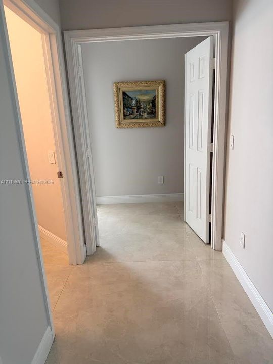 Neutral-toned tile flooring, six-panel interior doors, and neutral wall paint