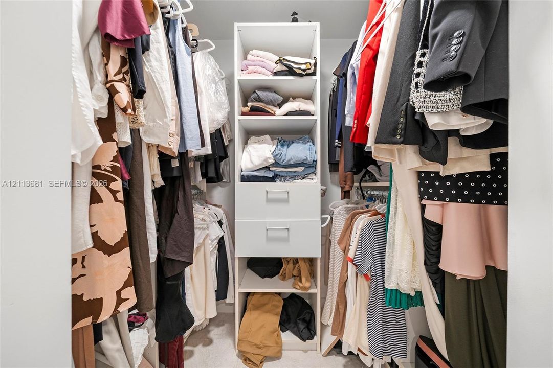 Built-in closet organizer featuring shelving, dual storage drawers, and dual hanging rods