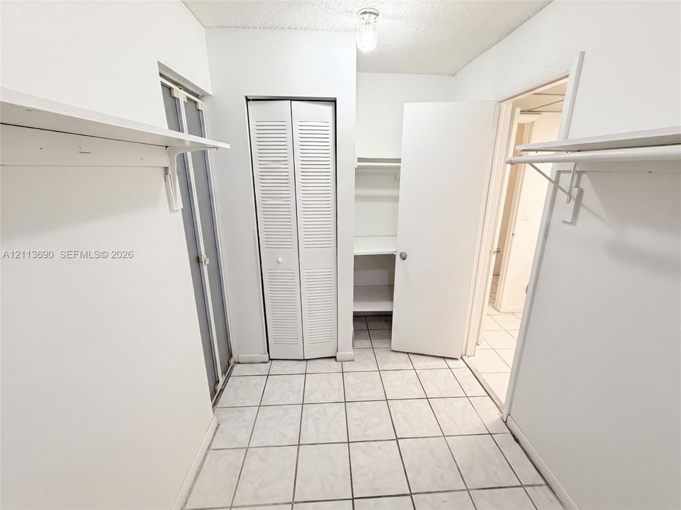 Tiled flooring, dual louvered-door closets, and built-in shelving