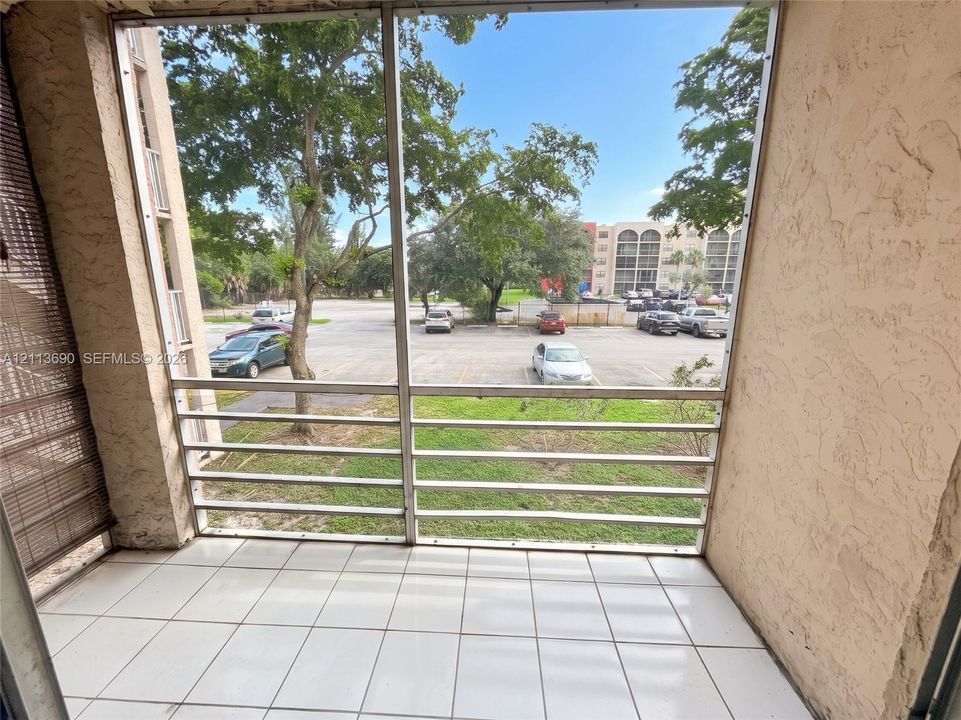 Screened-in balcony featuring white ceramic tile flooring and stucco wall finishes