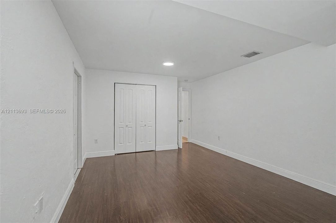 Room featuring wood-finish flooring, recessed lighting, and a double-door closet