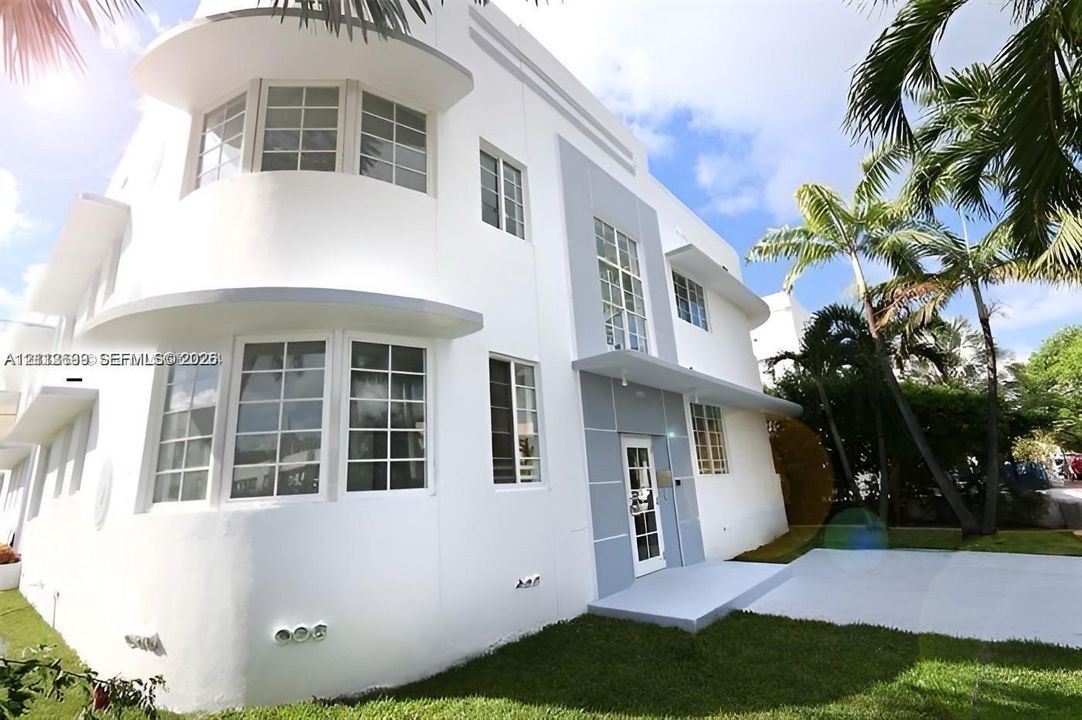 Art Deco exterior featuring curved architectural lines, horizontal belt courses, multi-pane windows, and a structured concrete entryway