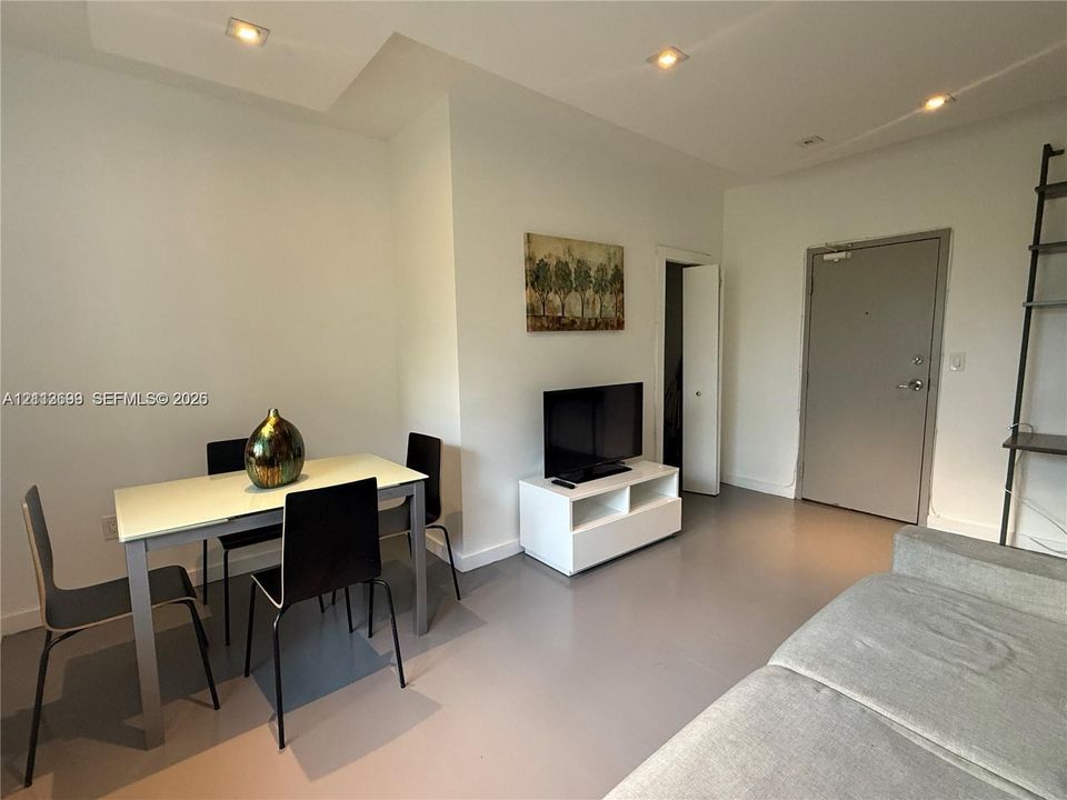 Interior space featuring neutral wall paint, recessed lighting, smooth-finish flooring, and a solid-core entry door