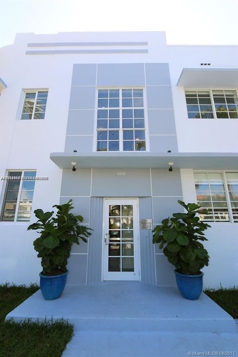 Art Deco exterior featuring a symmetrical facade, grid-patterned windows, a centered entryway, and architectural overhangs