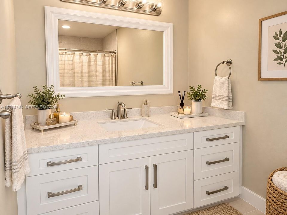White shaker-style vanity featuring a speckled composite countertop, an undermount sink, brushed nickel hardware, and a large framed mirror