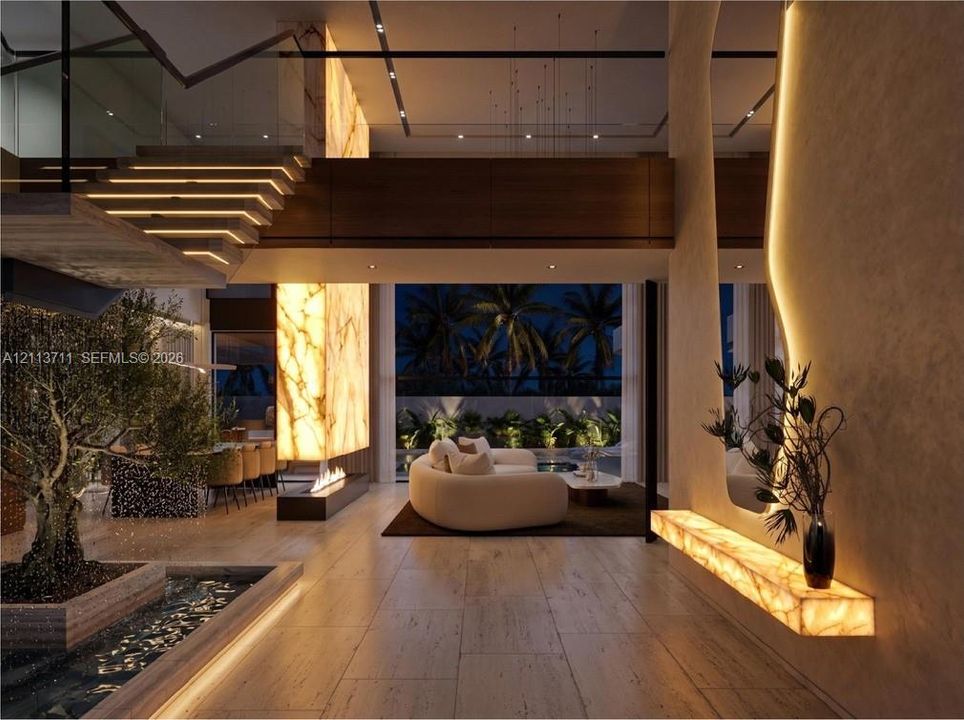 Open-concept living space featuring wood-finish flooring, a full-height backlit stone accent wall, a floating staircase with integrated lighting, and an indoor reflecting pool