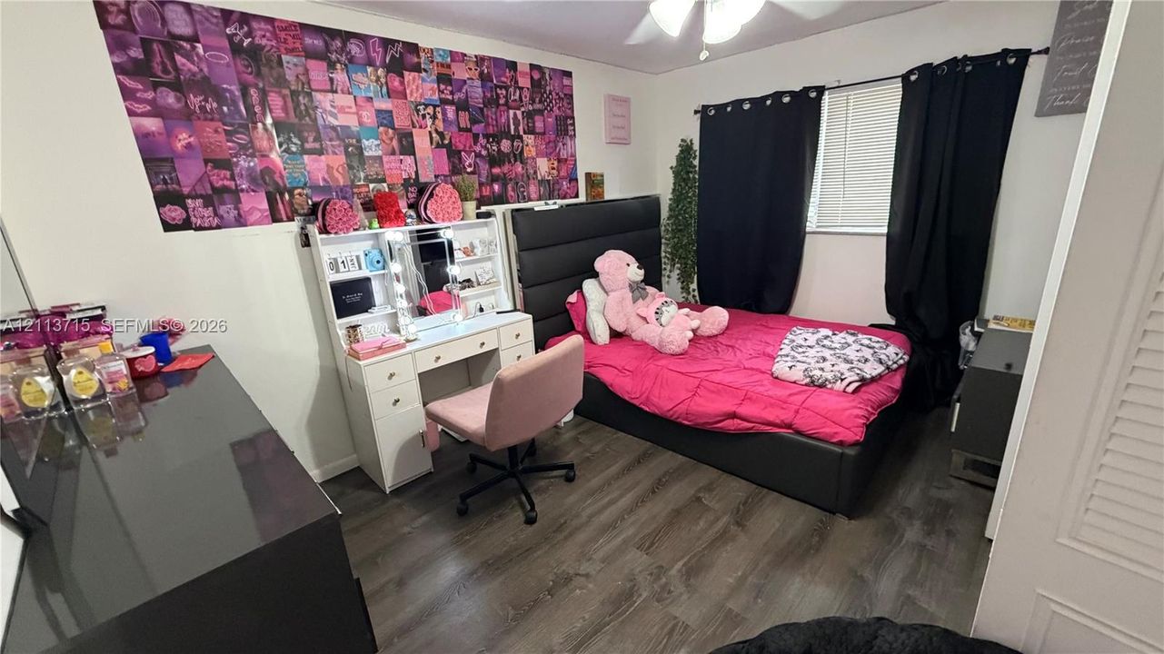 Wood-finish flooring, ceiling fan with integrated lighting, and window with blinds