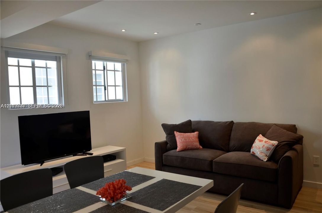 Bright room featuring recessed ceiling lighting, wood-finish flooring, and multi-pane windows