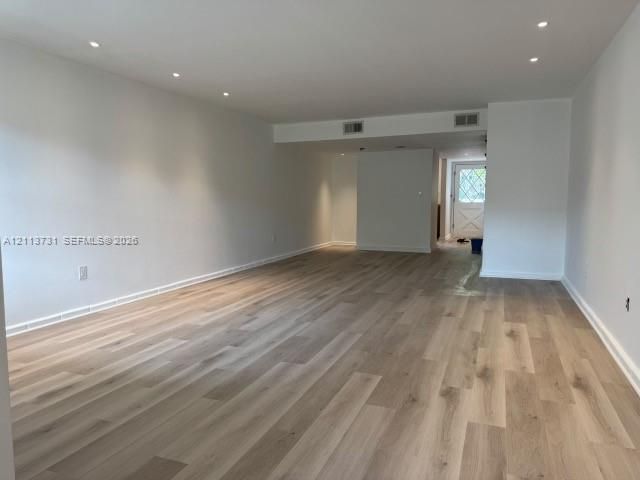 Interior space featuring wood-finish flooring, recessed lighting, and a paneled exterior door