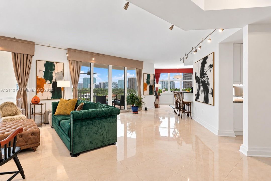 Open-concept interior featuring large-format tile flooring, floor-to-ceiling windows, and multi-directional track lighting