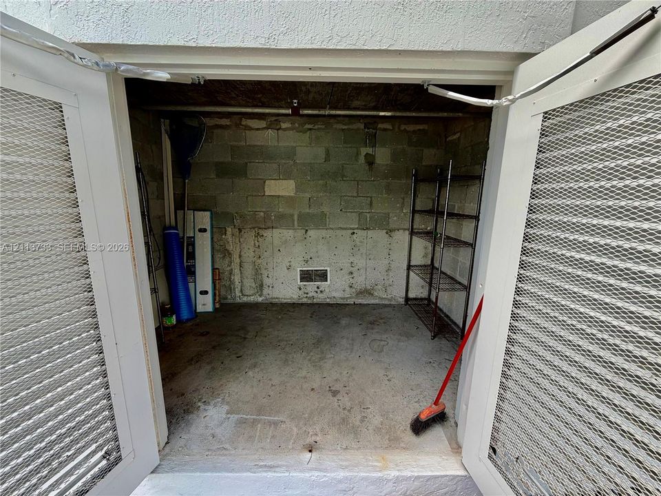 Electric hooks ups in your Private boat cabana Storage area with dual white louvered doors, concrete flooring, and masonry wall construction.