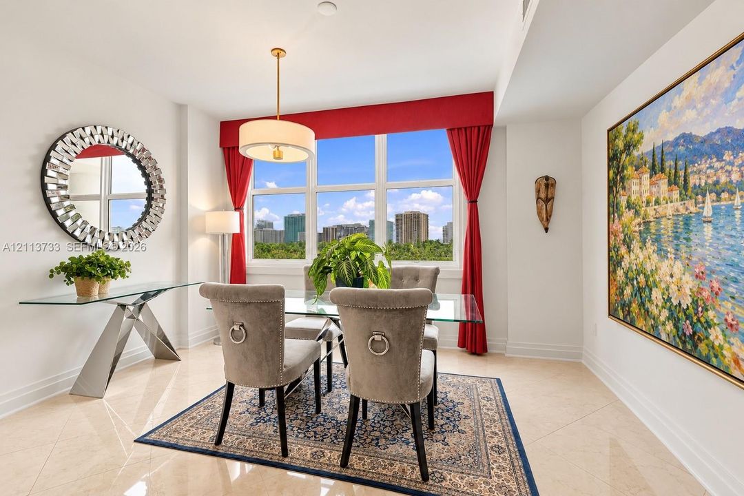 Large, multi-pane window featuring custom fabric valance and treatments, suspended drum-style pendant light, and polished neutral-tone tile flooring