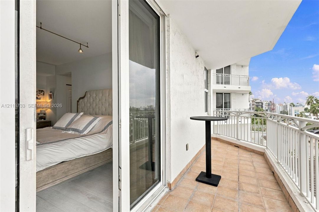 Private balcony featuring tile flooring and white metal railing, accessed through sliding glass doors